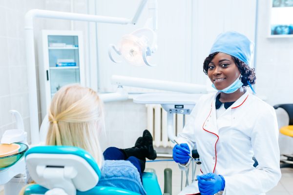 African american female dentist treating patient at clinic